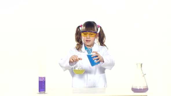 Little Girl with Ponytails in Uniform and Protective Glasses Making Chemical Experiments - Mixing