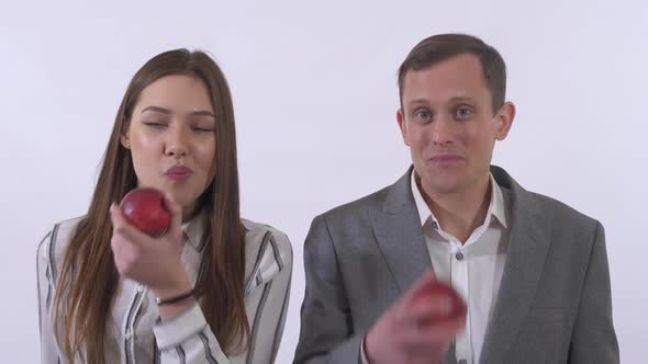 Portrait of Man and Woman Eating Apples and Smile Isolated