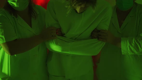 A Two Paramedic are Leading a Mad Ill Male Patient in Straitjacket Down Corridor in Mental Hospital