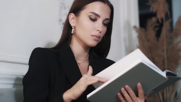 Beautiful Stylish Sophisticated Young Woman Model Is Reading a Book 