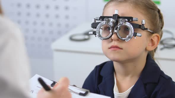 Kid in Optical Trial Frame Looking Doctor Prescribing Eyeglasses, Ophthalmology