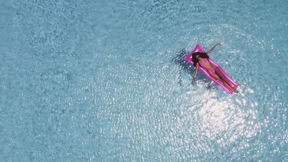 Lady with Slender Body Enjoying Her Alone Time By the Pool on a Pink Inflatable