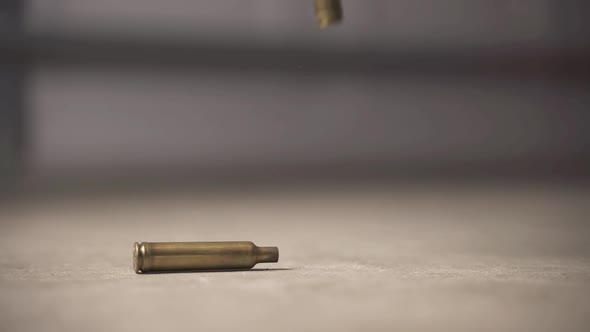 308 bullet shells falling to the ground in slow motion.