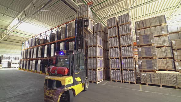 Forklift among the materials in the hangar. Floor and parquet storage.