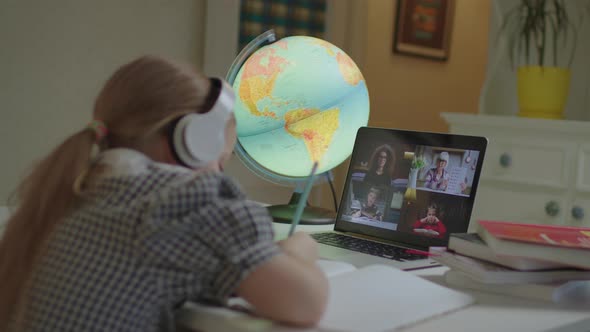 Child Learning Online with School Teacher and Pupils on Laptop Screen