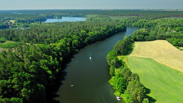 Small white boat on a large river among forests, Poland