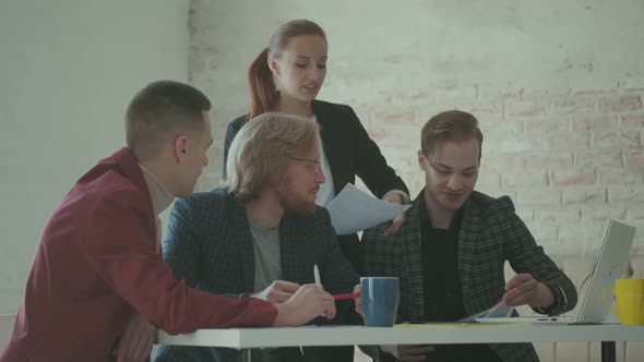 Colleagues Are Talking While Sitting at a Table in the Office. Creative Team Is Planning a Project.