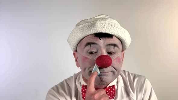 Emoji Clown - Sneezing Face. A mime clown sneezes and has a drop of mucus on his nose, then he eats