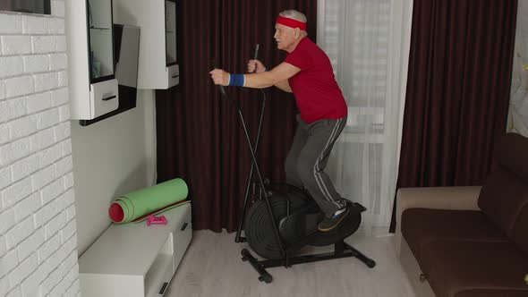 Active Healthy Senior Old Mature Man in Sportswear Using Orbitrek Training Cardio Workout at Home