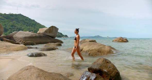 Woman Enjoys Her Summer on the Tropical Beach She Walks Out of Sea Against Beach Nature Rocks