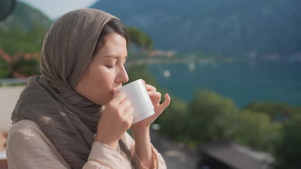 Woman Traditional Arab Dress Stands Terrace Enjoying Drinking Hot Coffee Tea Watching Views of