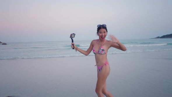 Happy Travel Live Stream Blogger in Bikini Running Towards the Sea Water at Sunset