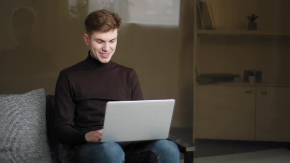 Happy Young Man Millennial User Making Online Call Using Laptop and Modern Computer App at Home for
