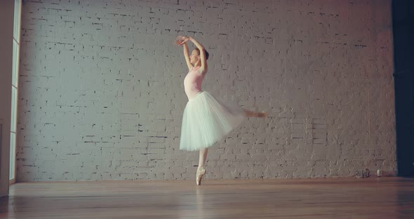 Beautiful Ballerina Stands on Pointe and Makes Smooth Movements with Her Hands Attitude