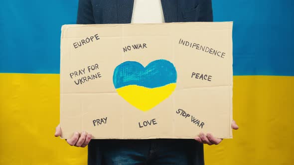 Boy Holds Cardboard with Heart Symbol for for the War in Ukraine