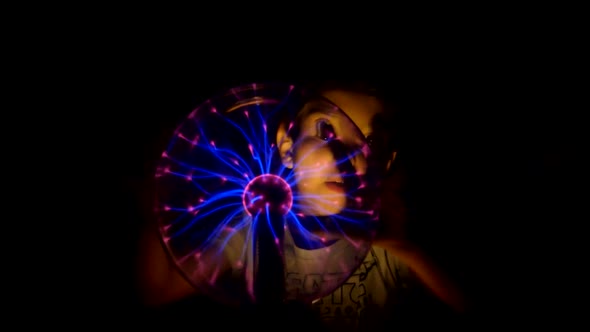 Boy Moves in the Tesla Lamp with His Hands