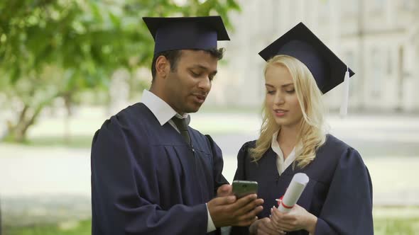 Mixed Graduate Student Showing Mobile App to Classmate Employment Opportunity