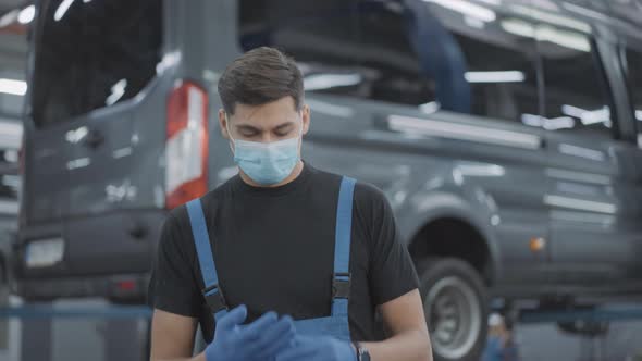 Confident Man in Coronavirus Face Mask Walking in Slowmo To Camera Taking Off Working Gloves