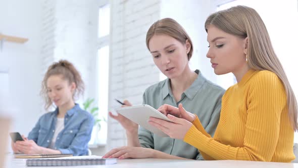 Young Female Designers Discussing and Working on Tablet