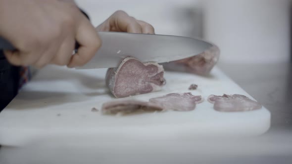 Close Side View of Chef Slicing Cured Meat on Kitchen Counter No Face