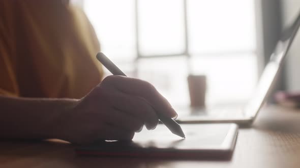 A Retoucher Girl Edits Photos on a Graphic Tablet