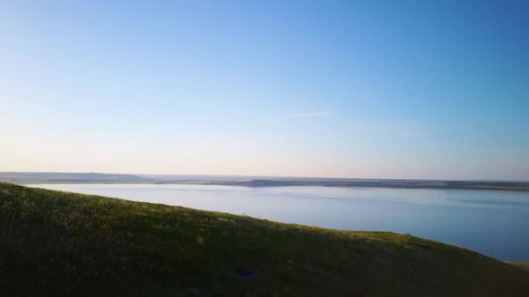 Aerial Video of a Lake in the Mountains at Sunset on a Sunny Summer Warm Day. Morning or Evening in