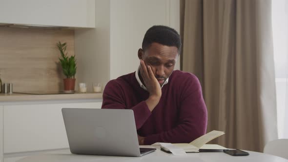 Young African American Man Checking Through His Bills and Feels Depressed and Upset