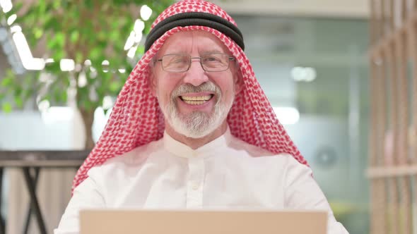 Old Arab Businessman with Laptop Smiling at the Camera 