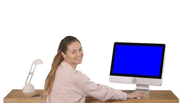 Cheerful woman sitting at the table with a computer in