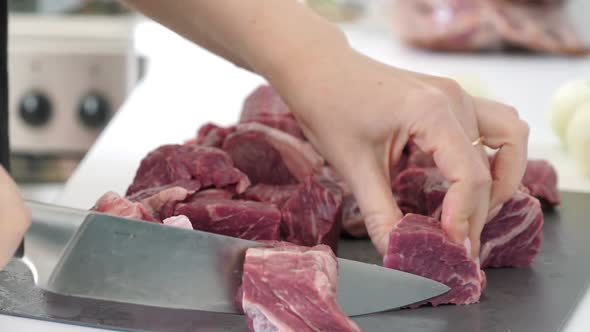 Woman Cutting Uncooked Beef on Pieces for Barbecue