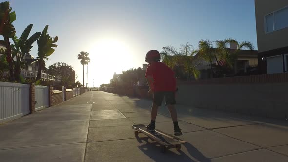 A boy skateboarding in a neighborhood.