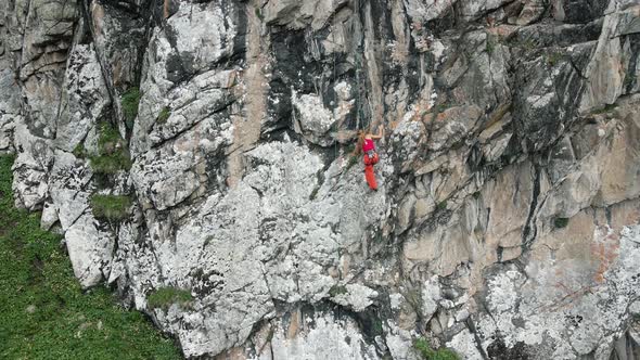 Woman Athlette Climbing on the High Rock in the Mountains