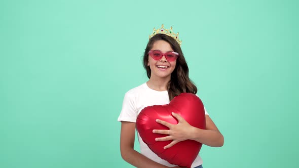 Happy Kid in Sunglasses and Princess Crown with Heart Party Balloon Show Peace Gesture Prom Queen