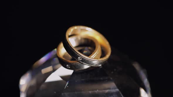 Wedding Rings Lying on Crystal Shining with Light Close Up Macro