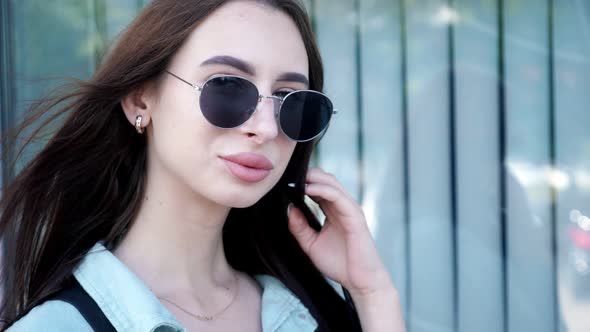 Pretty Brunette with Long Hair Takes Off Black Sunglasses