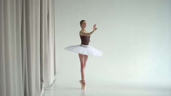 Ballerina in White Ballet Tutu Practicing in Dance Studio. Young Girl Dancing Classical Pas and