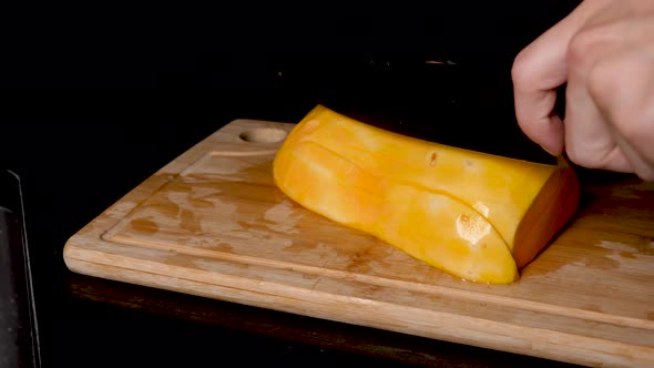 Locked Off View Butternut Pumpkin Being Sliced On Wooden Chopping Board