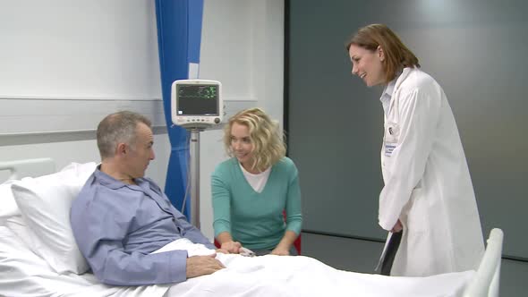 Female doctor talking with patient and his wife