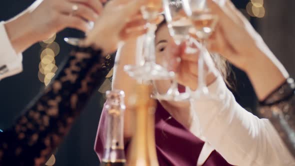 Closeup Portrait of Asian Girl Raising Glass of Champagne and Clinking Glasses with Aryone at Party