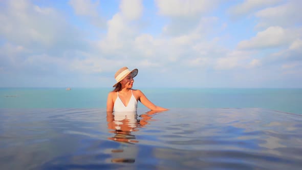 Young asian woman enjoy around outdoor swimming pool for leisure