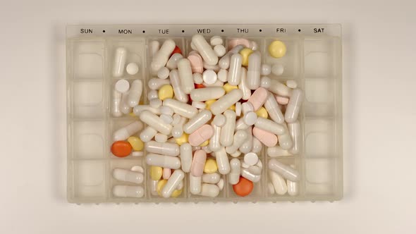 TOP VIEW: Heap Of Pills Fill A Pill Dispenser - Stop Motion