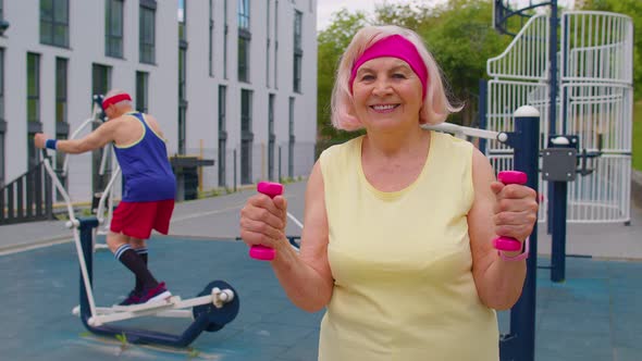 Senior Woman Grandmother Doing Active Training Weightlifting Exercising with Dumbbell on Playground