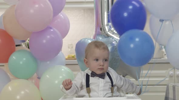 Happy Baby Boy Playing with Helium Balloons at His First Birthday Party Oneyearold Child Against the