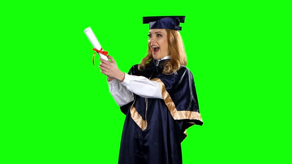 Girl with Graduation Gown and Diploma. Green Screen