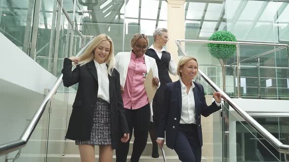 Group of Female Female Colleagues Descend the Stairs After the Seminar