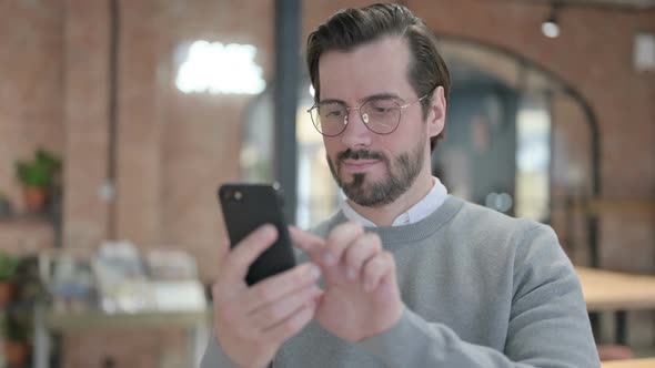 Young Man Browsing Internet on Smartphone