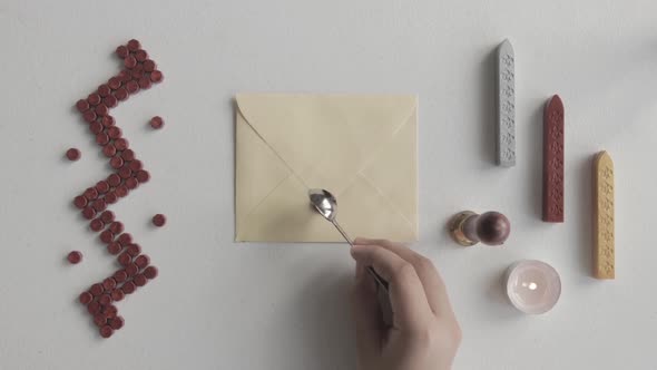 Close-up on Hand Putting Melted Red Wax on Letter Envelope