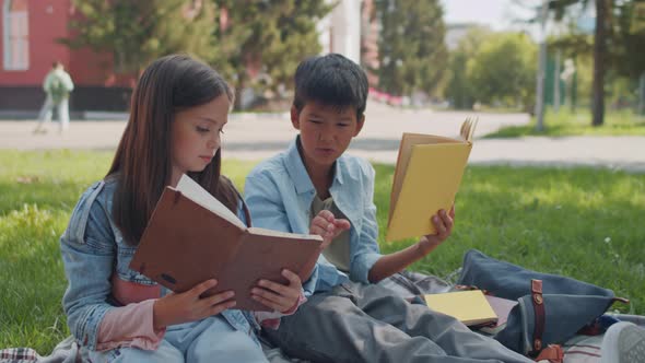 Boy and Girl Checking Homework in Schoolyard