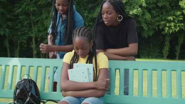 Empathetic African Teenage Girls Comforting Upset Student in Park