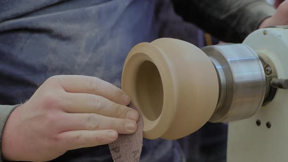 Slow Motion Carpenter Using Sandpaper for Sanding Piece of Wood on Lathe